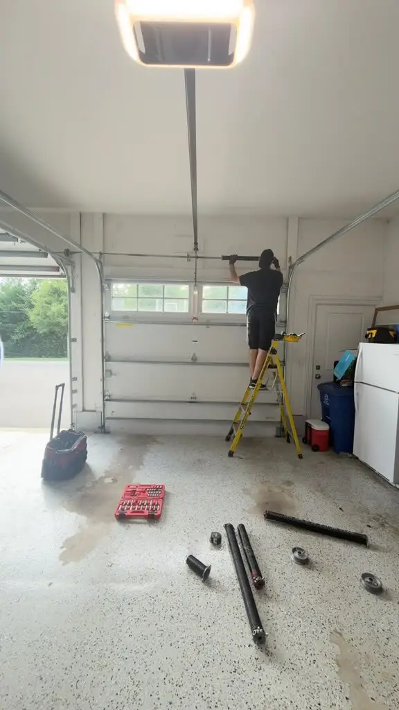 Technician replacing garage door torsion springs