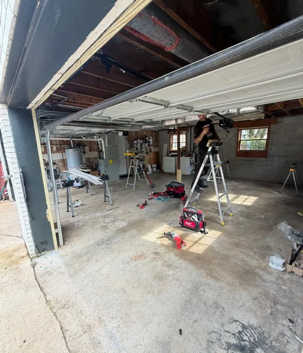 Technician servicing a garage door opener during a repair call